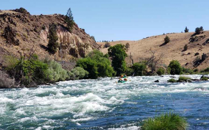 a group of girls navigate whitewater rapids on rafting expedition with outward bound